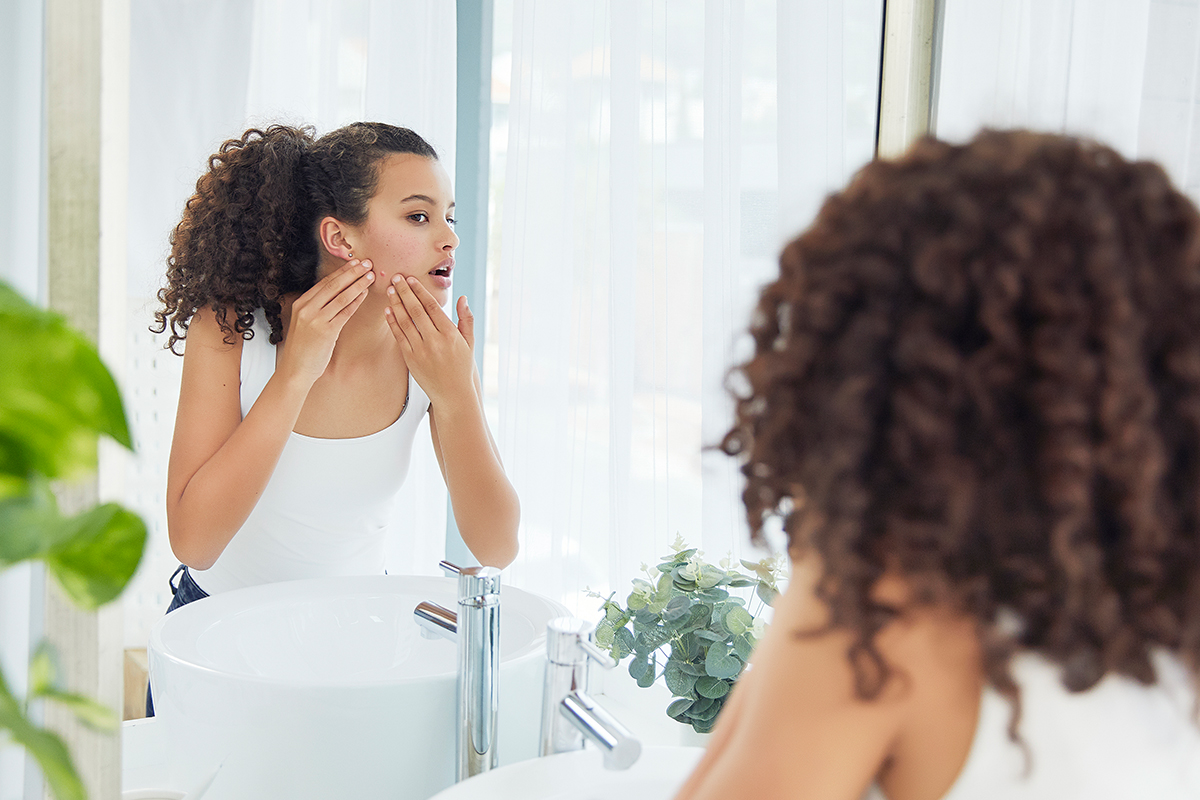 Woman looking in the mirror with no more acne in Palo Alto.